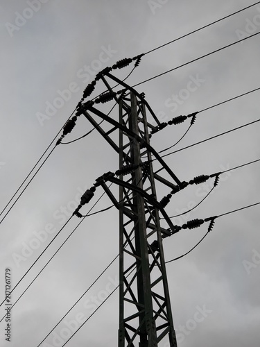Obraz na płótnie Electricity pylon and power lines silhouetted beneath gray clouds