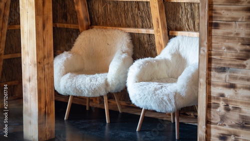 Quadro su tela Two cozy chairs in a rustic cabin with wooden walls and straw accents