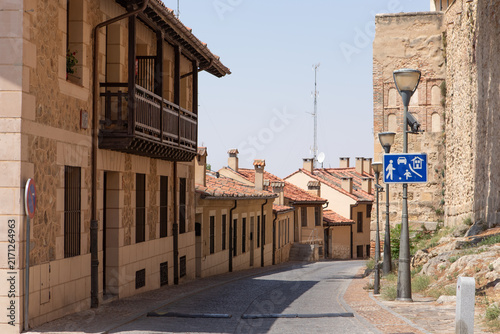 Walking street in a small town with stone buildings and a clear sky