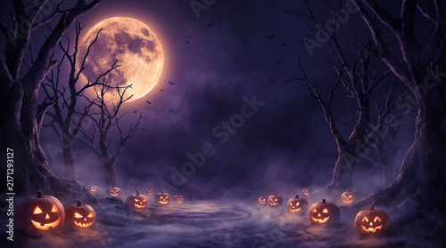 Haunted Halloween Pumpkin Glowing in a Dark Forest, Spooky Autumn Woods Background with Eerie Light and Mysterious Night Atmosphere