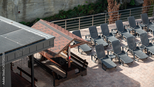 Fotografía Sun loungers and a shaded area near a river in an outdoor space during the day