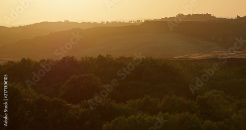 Golden sunset over rolling Tuscan hills with Pienza hilltop silhouette in Val d'Orcia, Tuscany, Italy