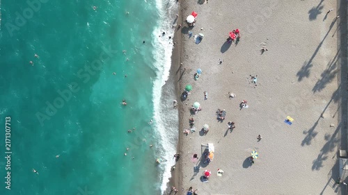 Aerial view of sunbathing people at the beach with colorful beach umbrellas