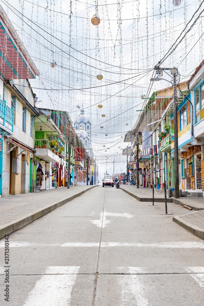 Fototapeta premium Colorful colonial street with hanging decorations in Filandia, Colombia