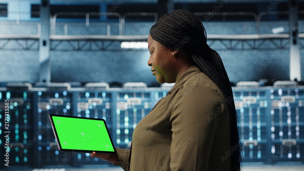Fototapeta premium Data center admin uses green screen tablet for server deployment