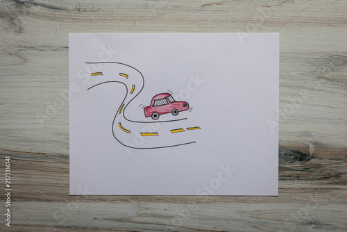 Flat lay graphic resource of hand drawn red cartoonish car traveling on a wavy road. 