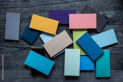 Over head view of scattered colorful rectangular wooden tiles on dark gray wood background