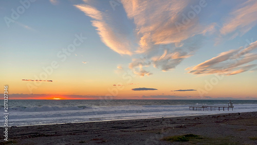 Dramatic sunset over ocean with expansive cloud formations and horizon