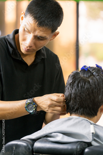 Barber styling client's hair in modern barbershop