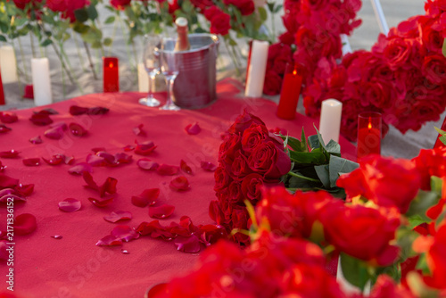 Couple shares a special moment during a marriage proposal on the beach in Spain surrounded by roses and candles
