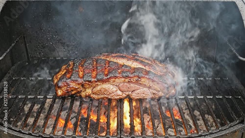 Succulent Brisket Grilling Over Flames With Smoke Creating A Mouthwatering Barbecue Scene Outdoors