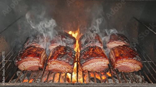 Succulent Smoked Barbecue Brisket Slices on Grill Surrounded by Smoke and Flames for Gastronomy and Culinary Projects