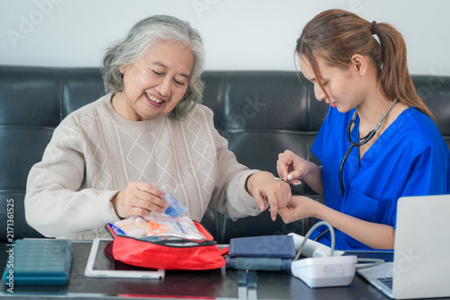 Fotografía Elderly woman nurse caregiver home diabetes glucose blood test during home visit