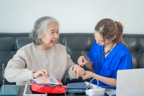 Canvastavla Senior woman nurse healthcare blood glucose test diabetes during home care visit