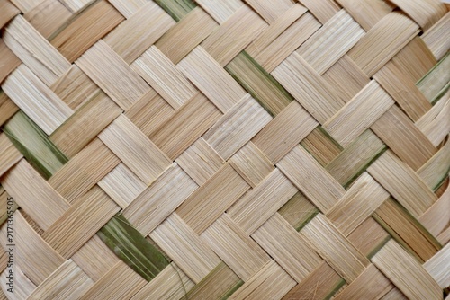 background texture of traditional hand woven natural bamboo strips in a crisscross pattern.