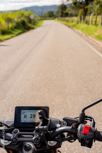 Motorcycle rider viewing the open road ahead, experiencing freedom and adventure on a journey through the countryside during a sunny day