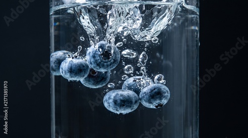 Fresh Blueberries Falling into Clear Water with Air Bubbles High Speed Macro
