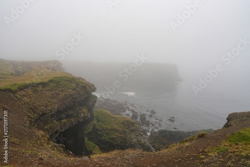 A misty cliffside coastline between the villages of Hellnar and Arnarstapi in western Iceland.