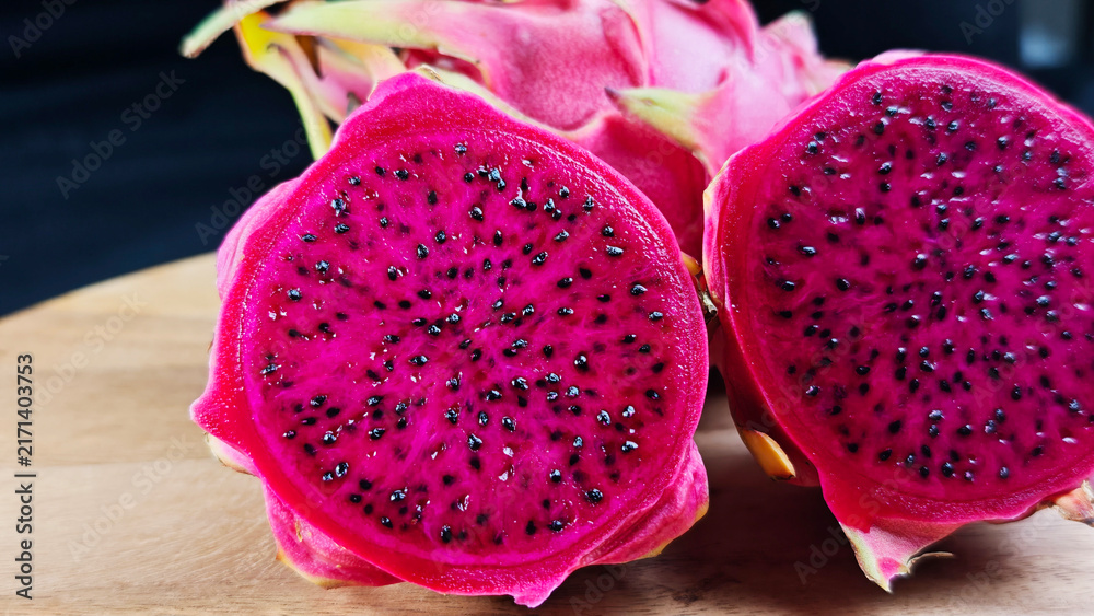 Naklejka premium Fresh Dragon fruit on wooden with black background