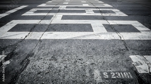 Detailed monochrome perspective of a textured crosswalk with weathered stripes on asphalt creating a minimalist geometric urban pattern crosswalk pedestrian street asphalt stripes road walking safety