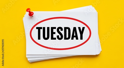 Tuesday word written on white paper pinned by a red pushpin