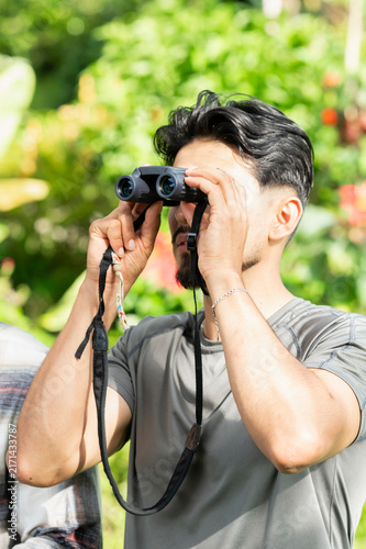 Cuadro en lienzo Man bird watching using binoculars in nature