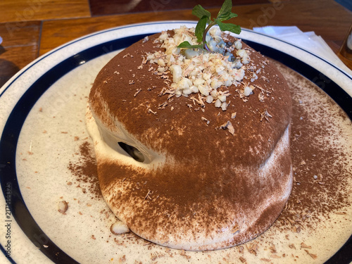 Konstfotografi Fluffy cocoa-dusted souffle pancake with chopped nuts