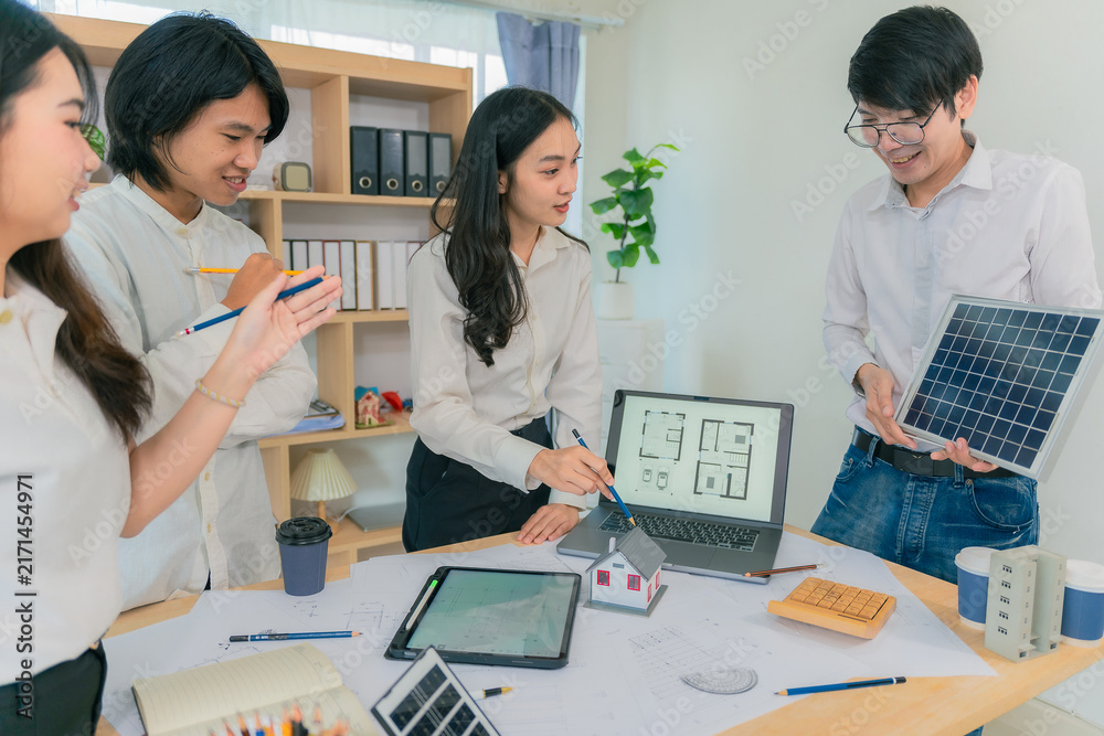 Fototapeta premium Diverse Architectural Team Collaborating on Sustainable Solar House Design and Construction Blueprints