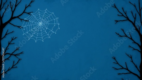 Spooky spider web hanging between dark bare tree branches on a blue night background