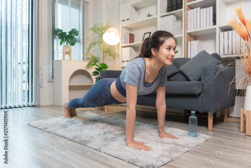 A sporty woman in sportswear exercises at home	