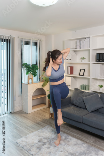 A sporty woman in sportswear exercises at home	