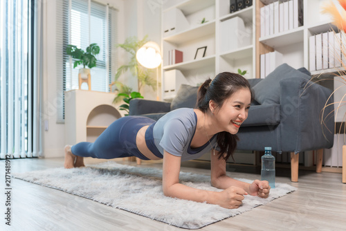A sporty woman in sportswear exercises at home	