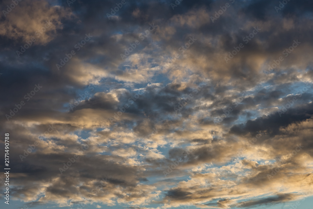 Fototapeta premium Dramatic sky with golden hour clouds and deep blue sky