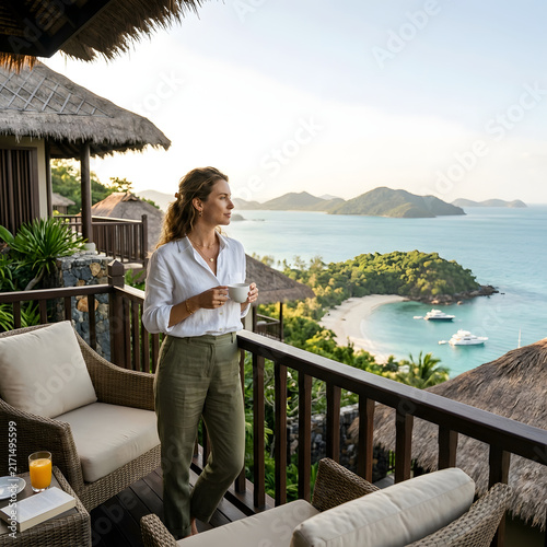 Woman relaxing on balcony overlooking tropical beach
