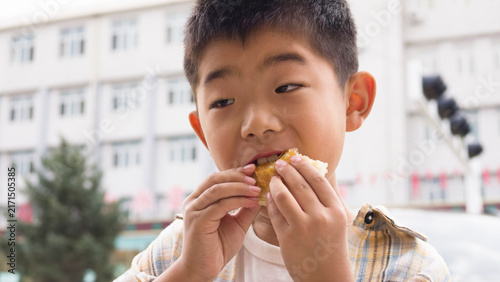 Foto Chinese kid eating local specialty Duijia, a traditional Chinese snack from Jingpeng Town, Hexigten Banner, Inner Mongolia