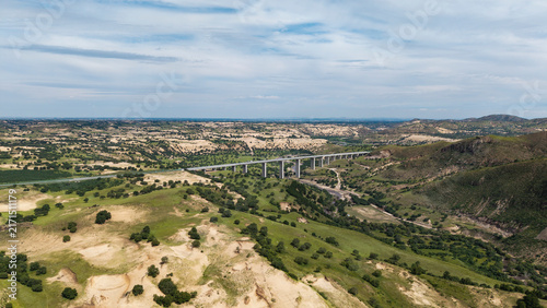 Aerial shot of Saling River Grand Bridge spanning across the river. Grand bridge construction integrated with natural landscape, transportation infrastructure in Inner Mongolia grassland area.