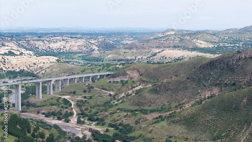 Aerial shot of Saling River Grand Bridge spanning across the river. Grand bridge construction integrated with natural landscape, transportation infrastructure in Inner Mongolia grassland area.