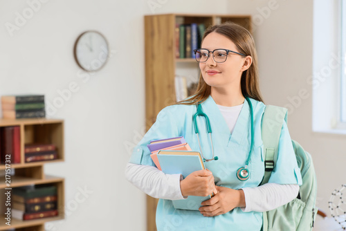 Foto Medical education and healthcare career, young female student in scrubs with boo