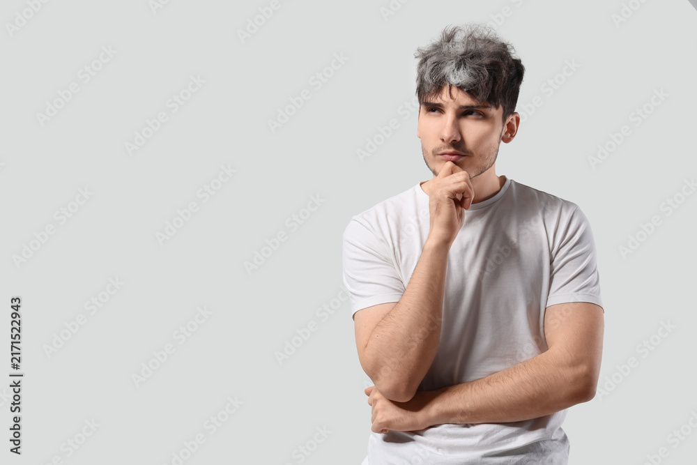 Fototapeta premium Thoughtful young man with graying hair on white background
