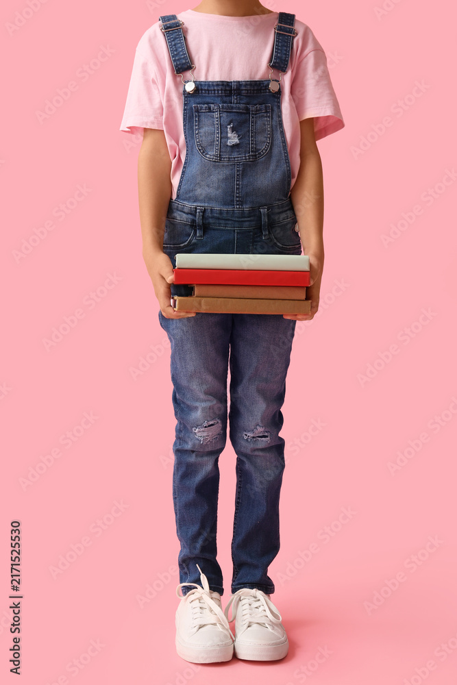 Fototapeta premium Little girl with stack of books on pink background