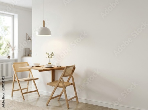 Minimalist interior with a space-saving wall-mounted wooden dining table, two rattan folding chairs, and a white dome pendant light against a large blank white wall backdrop.