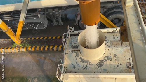 An industrial tanker fills from a high‑pressure overhead pipe at a refilling bay near EGA in Dubai’s logistics zone.