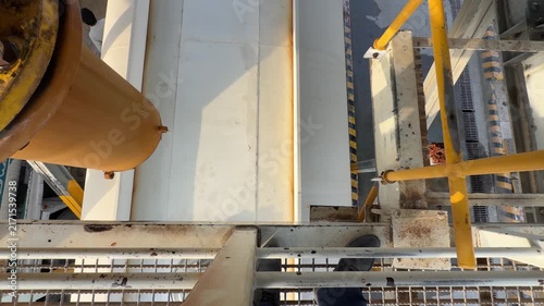 An industrial tanker fills from a high‑pressure overhead pipe at a refilling bay near EGA in Dubai’s logistics zone.