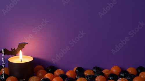 Halloween candle bat purple background berry flame shadow spooky autumn decoration creates mysterious setting with glowing light, dark shadow, and festive atmosphere