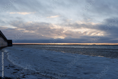 Foto Cold evening landscape of northern european waterway covered in slush ice under moody cloudy sky at twilight