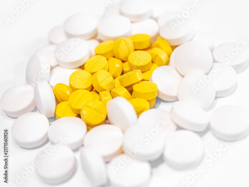 Bild auf Leinwand Group of white and yellow medical pills and tablets heap, colorful pharmaceutical background