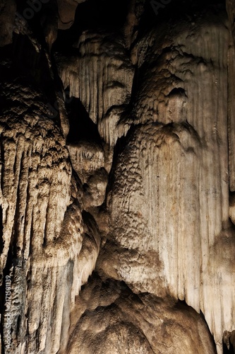 Stalactites hang from a limestone cave ceiling creating a natural wonder.