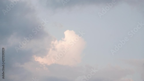 Clouds in the sky during sunset with shades of light and dark colors above a calm landscape