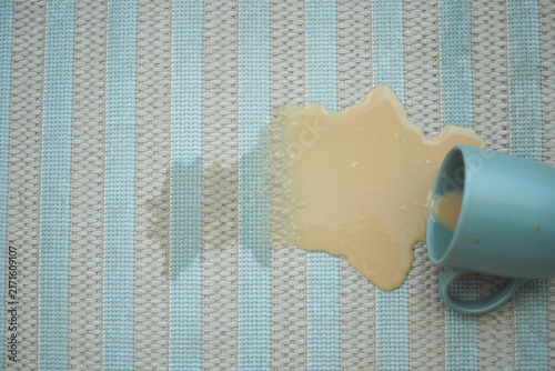Fotografie Cup spills drink on a rug during a morning hour