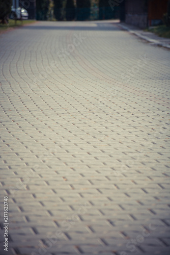 Cuadro en lienzo Empty cobblestone street with gentle curves on a quiet day.